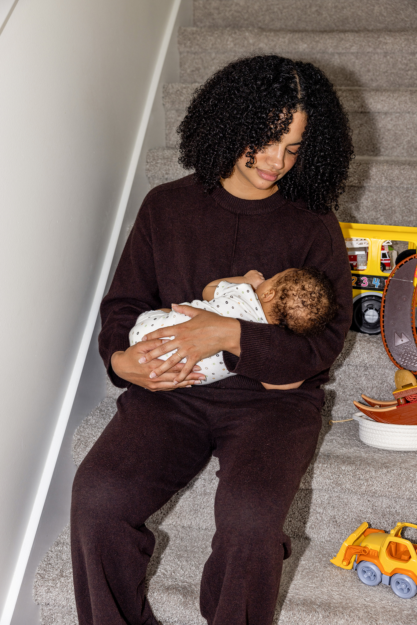 A mother holding her baby on the stairs at home